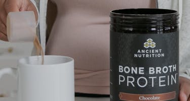 bone broth next to white cup